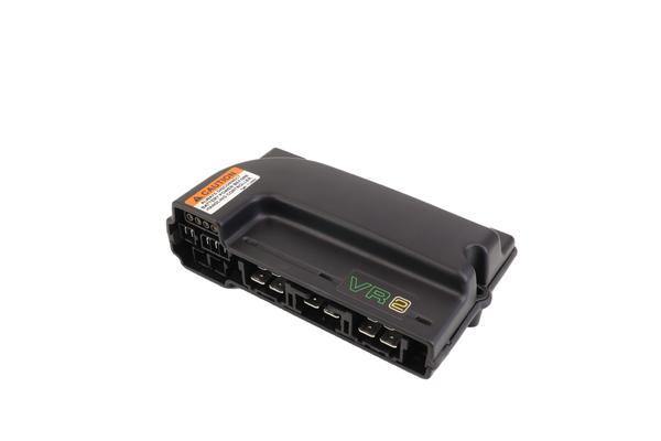 a black control module with an orange and white warning sticker and multiple connection ports, shown from the front at an angle