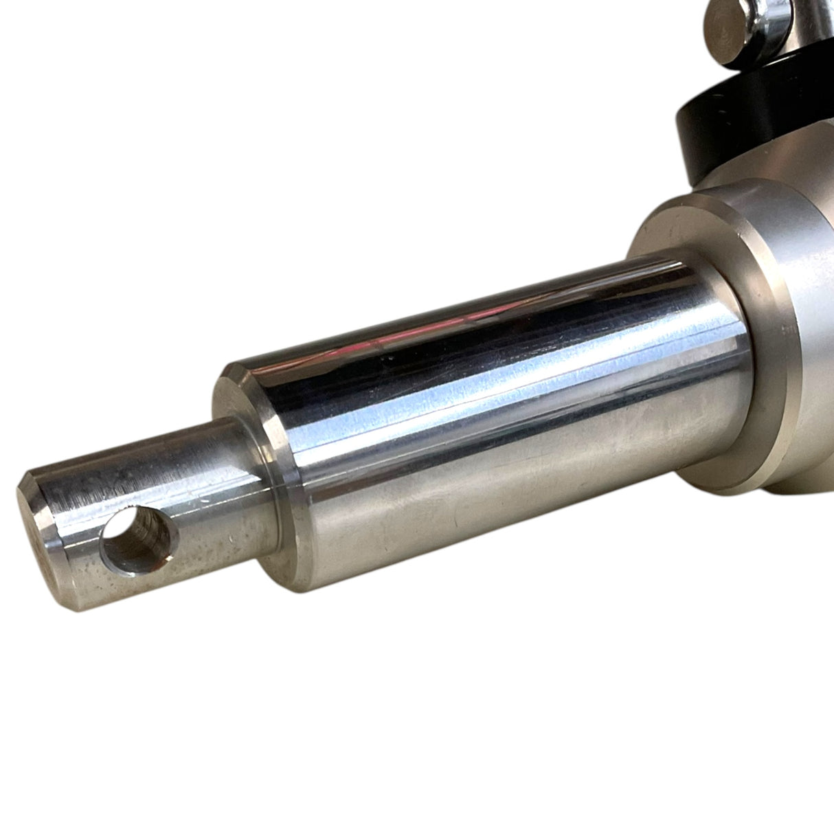 A close-up of a polished metallic cylindrical shaft or spindle component with a hole near the end, shown against a plain white background.