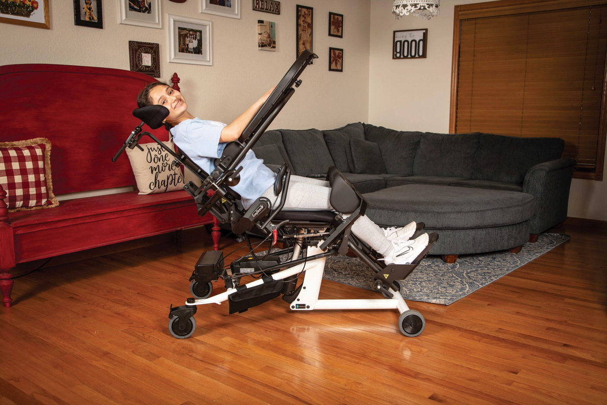 Young girl demoing EasyStand Bantam Medium Standing Frame in living room