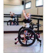 Child in a KidWalk with arms raised in an indoor setting