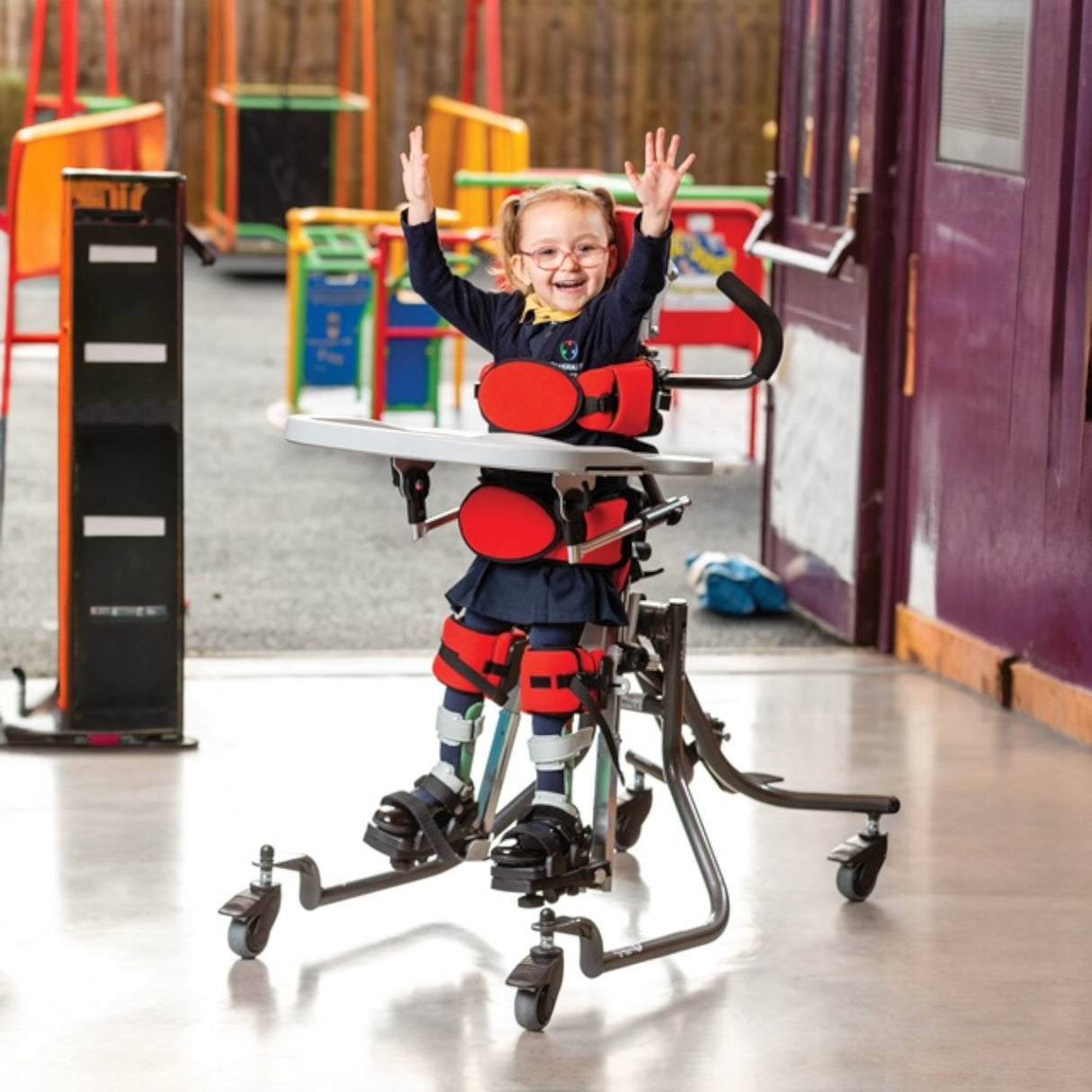 Child using a standing frame in a school hallway