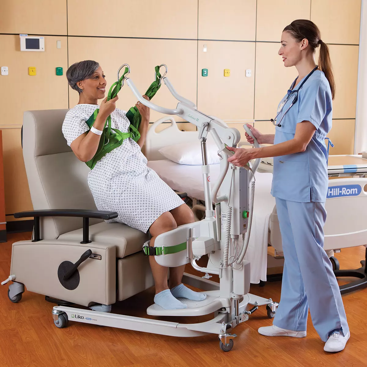 Nurse operating Liko Sabina II Electric Sit-to-Stand Patient Lift with patient
