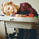 Child playing with toys at a table, smiling